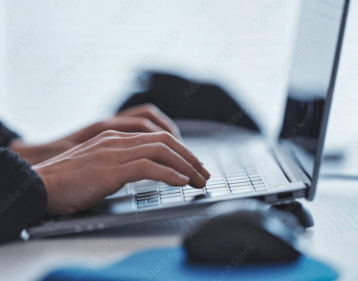 ノートパソコンでタイピングしている男性